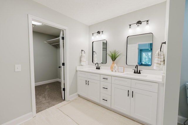 1405 SE Broad St, Murfreesboro, TN 37130 - bathroom featuring double vanity, a walk in closet, and baseboards