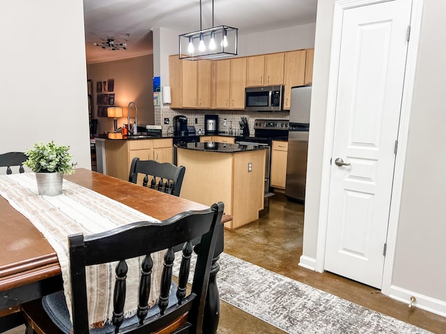 1803 Broadway Unit 509, Nashville, TN 37203 - kitchen with light brown cabinets, stainless steel appliances, dark countertops, concrete floors, and decorative backsplash