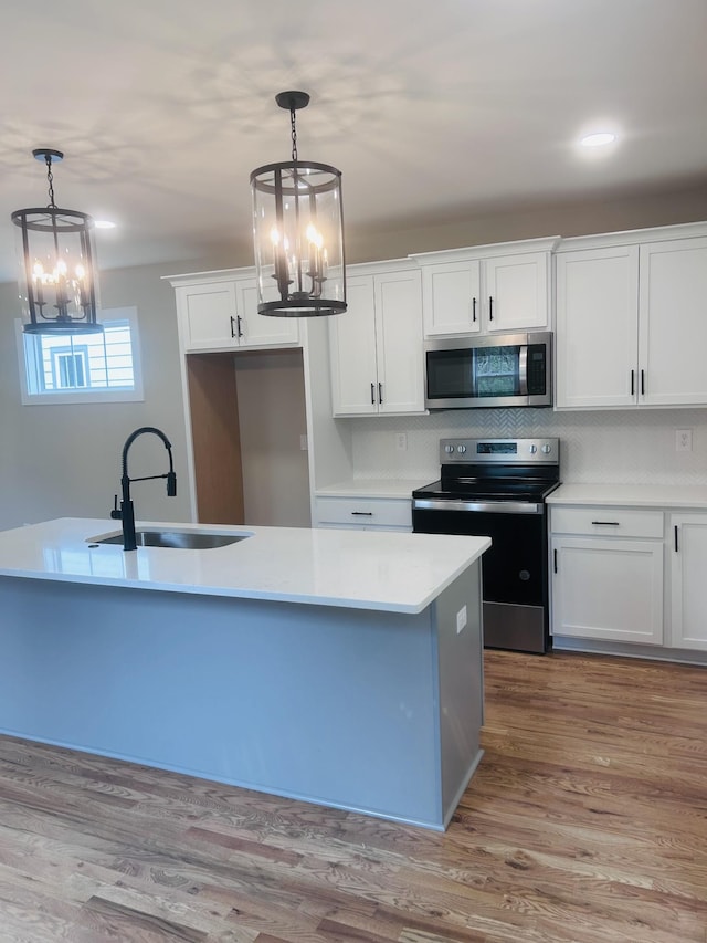 5930 Carl Pl, Nashville, TN 37209 - kitchen with stainless steel appliances, a chandelier, a sink, and white cabinets