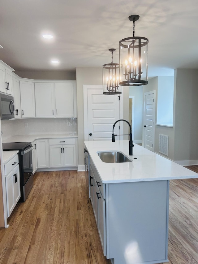 5930 Carl Pl, Nashville, TN 37209 - kitchen featuring a sink, black appliances, light countertops, a chandelier, and wood finished floors