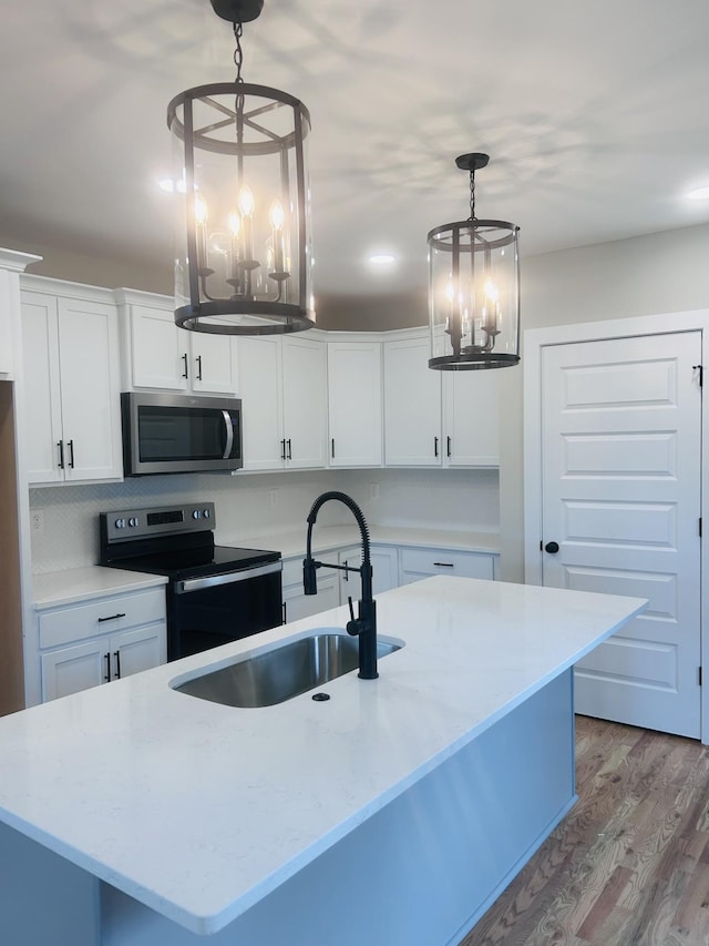 5930 Carl Pl, Nashville, TN 37209 - kitchen with stainless steel appliances, a chandelier, wood finished floors, a sink, and white cabinetry