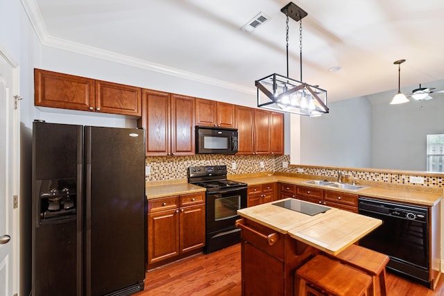 735 Tulip Grove Rd Unit 325, Hermitage, TN 37076 - kitchen featuring black appliances, a sink, wood finished floors, a peninsula, and decorative backsplash