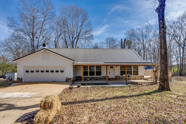 8208 Graham Rd, Chattanooga, TN 37421 - view of front of home with covered porch, an attached garage, concrete driveway, metal roof, and board and batten siding