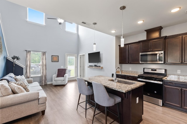 1339 Raden Dr, Lebanon, TN 37087 - kitchen with stainless steel appliances, a sink, open floor plan, dark brown cabinets, and a ceiling fan