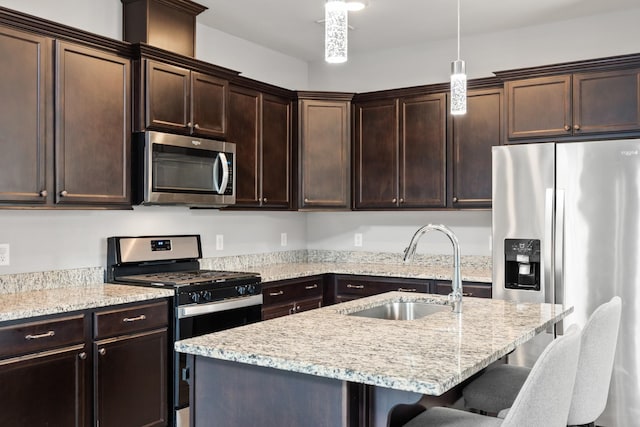 1339 Raden Dr, Lebanon, TN 37087 - kitchen featuring appliances with stainless steel finishes, a sink, a kitchen bar, dark brown cabinetry, and hanging light fixtures