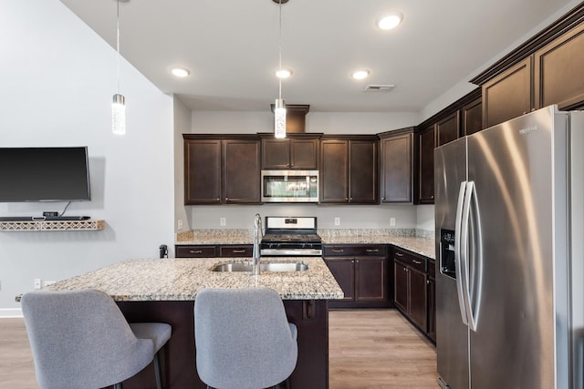 1339 Raden Dr, Lebanon, TN 37087 - kitchen with appliances with stainless steel finishes, dark brown cabinets, a sink, light wood-type flooring, and light stone counters