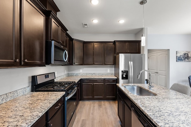 1339 Raden Dr, Lebanon, TN 37087 - kitchen featuring stainless steel appliances, a sink, light wood-type flooring, dark brown cabinetry, and pendant lighting