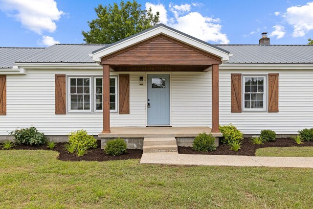 1371 Pomona Rd, Dickson, TN 37055 - view of front of house featuring covered porch, metal roof, a front yard, and a chimney