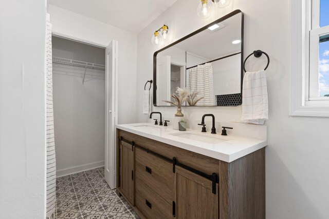 1371 Pomona Rd, Dickson, TN 37055 - bathroom featuring double vanity, a spacious closet, and baseboards