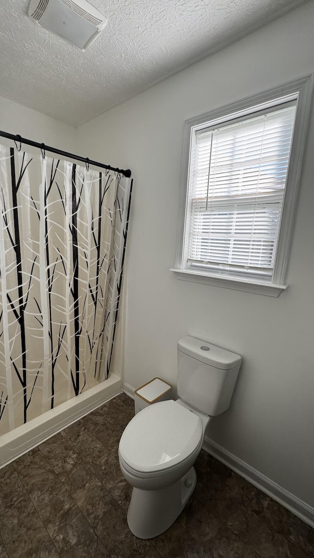 312 Pappy Dr, Oak Grove, KY 42262 - bathroom featuring toilet, a textured ceiling, baseboards, and a shower with curtain