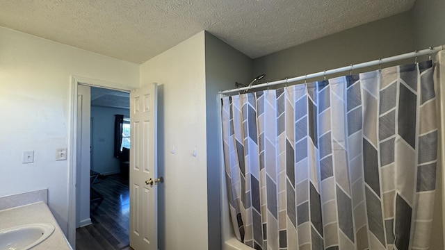 312 Pappy Dr, Oak Grove, KY 42262 - full bath with wood finished floors, vanity, a textured ceiling, and shower / tub combo