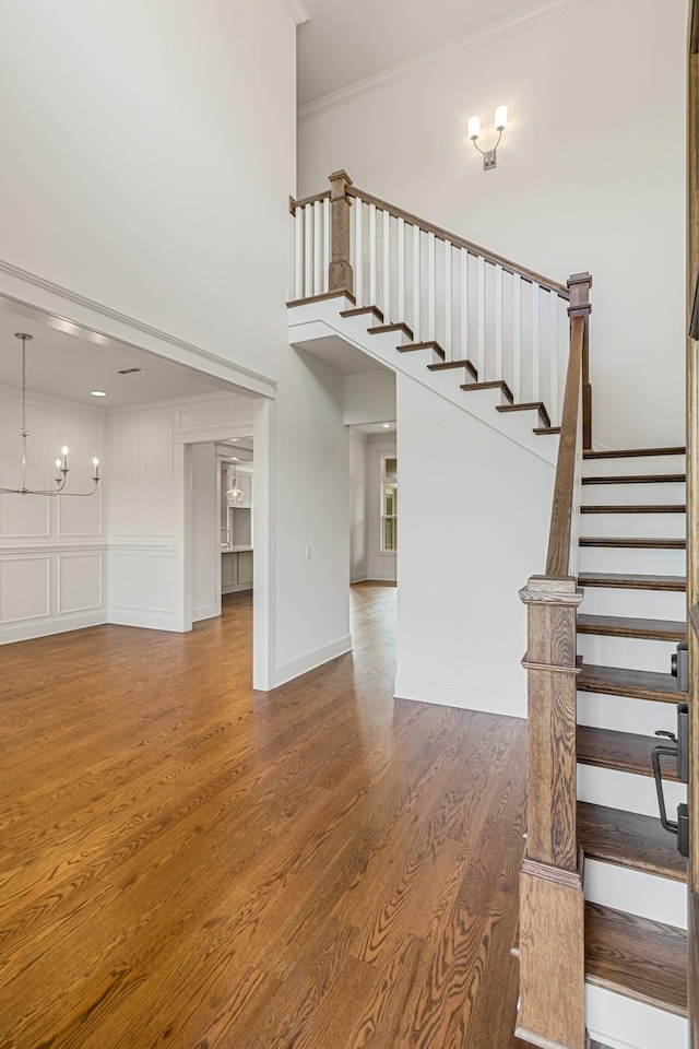 7100 Twelve Corners Rd, Lascassas, TN 37085 - unfurnished living room with crown molding, wood finished floors, stairs, a chandelier, and a high ceiling