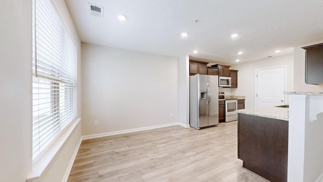249 Edgefield Ct, Pleasant View, TN 37146 - kitchen with appliances with stainless steel finishes, dark brown cabinets, light stone counters, light wood-type flooring, and recessed lighting