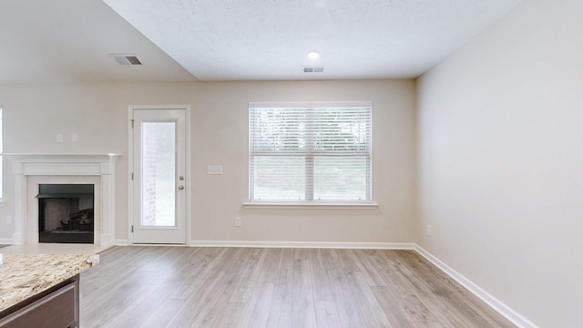 249 Edgefield Ct, Pleasant View, TN 37146 - unfurnished living room featuring light wood-style flooring and a fireplace with flush hearth
