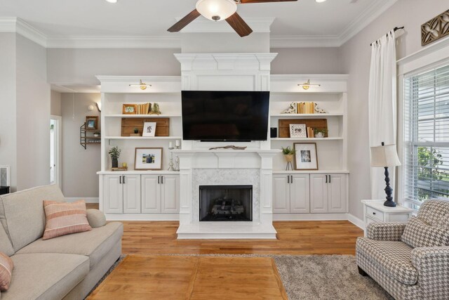 7579 Nightfall Cir, Ooltewah, TN 37363 - living area featuring a high end fireplace, a ceiling fan, light wood-type flooring, ornamental molding, and baseboards