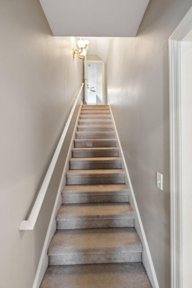 7579 Nightfall Cir, Ooltewah, TN 37363 - stairway featuring a chandelier, carpet, and baseboards