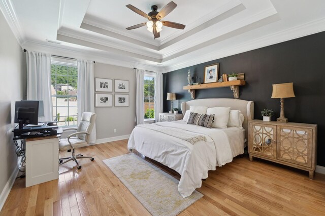 7579 Nightfall Cir, Ooltewah, TN 37363 - bedroom featuring multiple windows, an office area, ornamental molding, a tray ceiling, and light wood finished floors