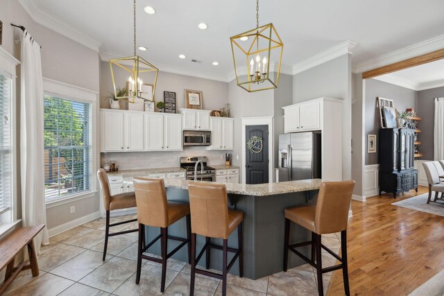 7579 Nightfall Cir, Ooltewah, TN 37363 - kitchen with stainless steel appliances, a chandelier, ornamental molding, white cabinets, and pendant lighting