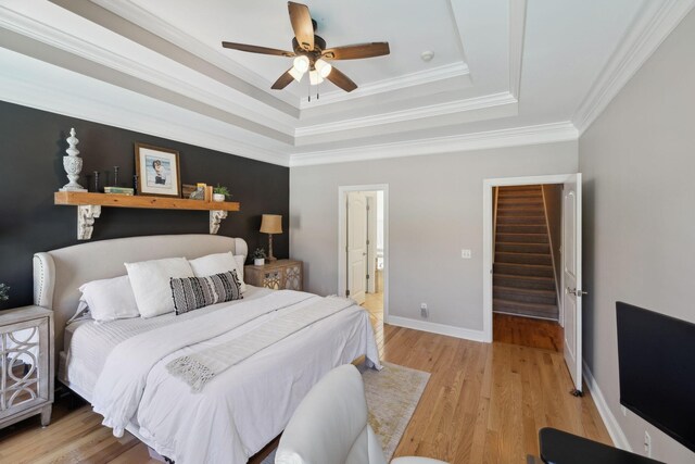 7579 Nightfall Cir, Ooltewah, TN 37363 - bedroom featuring a raised ceiling, light wood-style floors, crown molding, baseboards, and connected bathroom