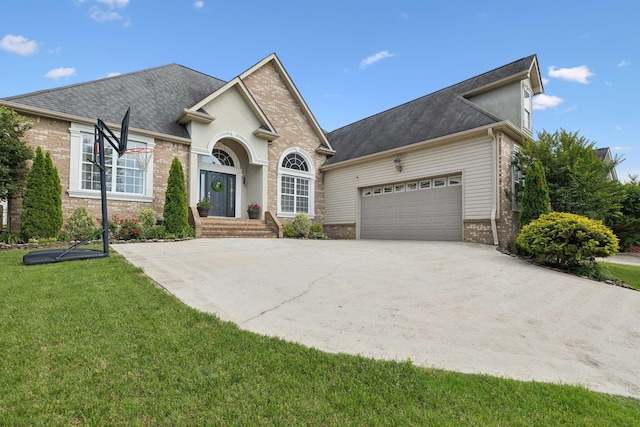 7579 Nightfall Cir, Ooltewah, TN 37363 - view of front of house with an attached garage, brick siding, a front lawn, and roof with shingles