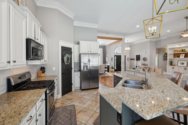 7579 Nightfall Cir, Ooltewah, TN 37363 - kitchen featuring stainless steel appliances, a sink, a breakfast bar, white cabinetry, and ornamental molding