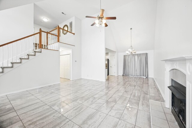 3716 S Jot Dr, Clarksville, TN 37040 - unfurnished living room with high vaulted ceiling, a fireplace, ceiling fan, a chandelier, and stairs
