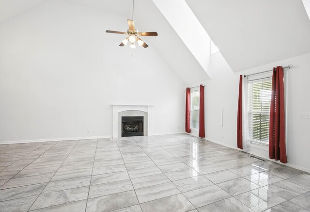 3716 S Jot Dr, Clarksville, TN 37040 - unfurnished living room with high vaulted ceiling, marble look tiles, a tile fireplace, ceiling fan, and baseboards