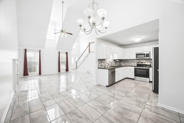 3716 S Jot Dr, Clarksville, TN 37040 - kitchen featuring appliances with stainless steel finishes, light marble finish floors, a towering ceiling, and baseboards