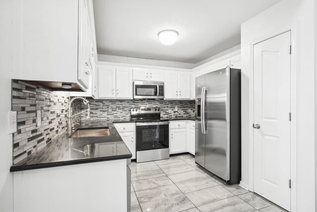 3716 S Jot Dr, Clarksville, TN 37040 - kitchen with stainless steel appliances, a sink, white cabinetry, light marble finish flooring, and backsplash