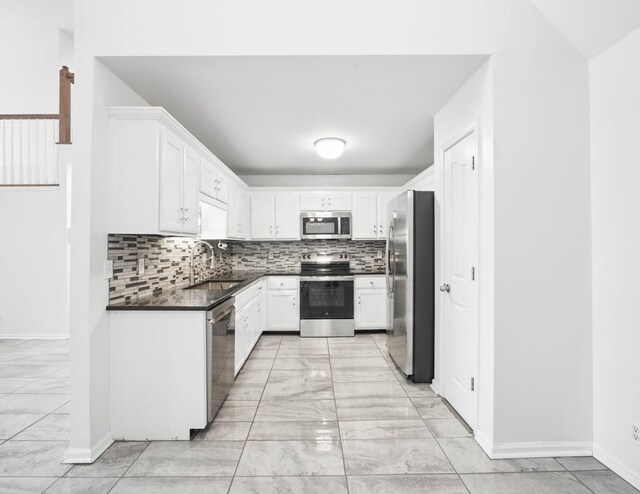 3716 S Jot Dr, Clarksville, TN 37040 - kitchen featuring stainless steel appliances, a sink, light marble finish flooring, dark countertops, and white cabinets
