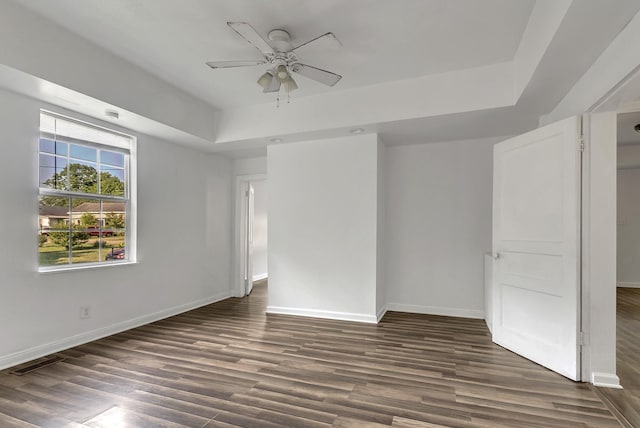 226 Higdon St, Lynnville, TN 38472 - spare room with a raised ceiling, ceiling fan, dark wood-type flooring, and baseboards