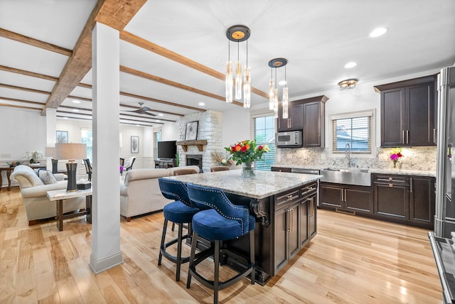 127 Copperstone Dr, Clarksville, TN 37043 - kitchen with a sink, open floor plan, stainless steel microwave, tasteful backsplash, and beam ceiling