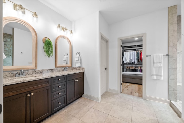 127 Copperstone Dr, Clarksville, TN 37043 - full bathroom with double vanity, a walk in closet, tile patterned floors, baseboards, and tiled shower
