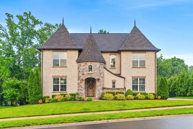 127 Copperstone Dr, Clarksville, TN 37043 - french country style house featuring roof with shingles, a front yard, and brick siding