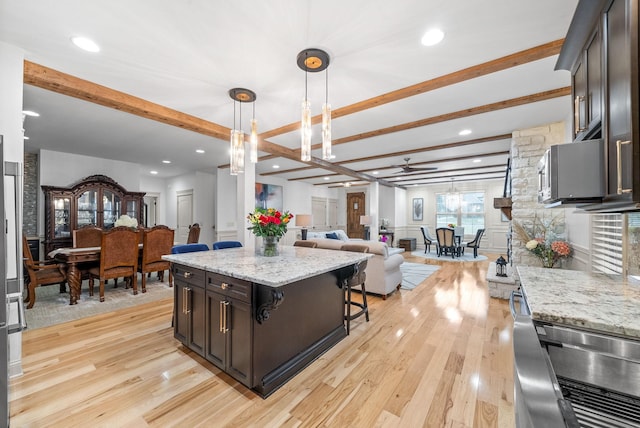 127 Copperstone Dr, Clarksville, TN 37043 - kitchen featuring beamed ceiling, light wood-type flooring, open floor plan, hanging light fixtures, and light stone countertops