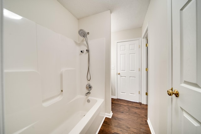 3889 Mackenzie Dr, Clarksville, TN 37042 - bathroom featuring wood finished floors, shower / bath combination, a textured ceiling, and baseboards