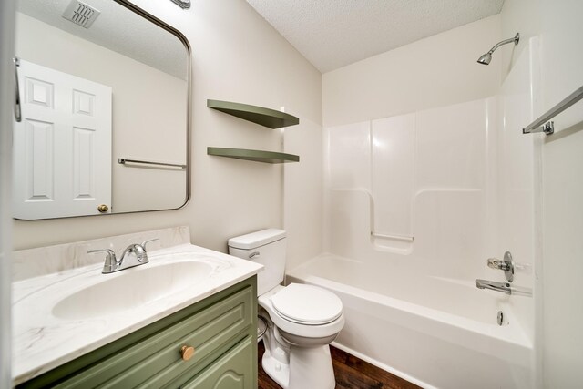 3889 Mackenzie Dr, Clarksville, TN 37042 - bathroom featuring a textured ceiling, toilet, vanity, tub / shower combination, and wood finished floors