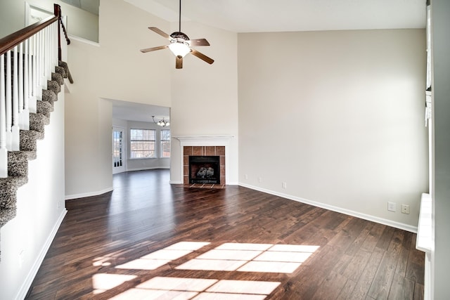 3889 Mackenzie Dr, Clarksville, TN 37042 - unfurnished living room featuring a ceiling fan, dark wood-style floors, baseboards, stairs, and high vaulted ceiling