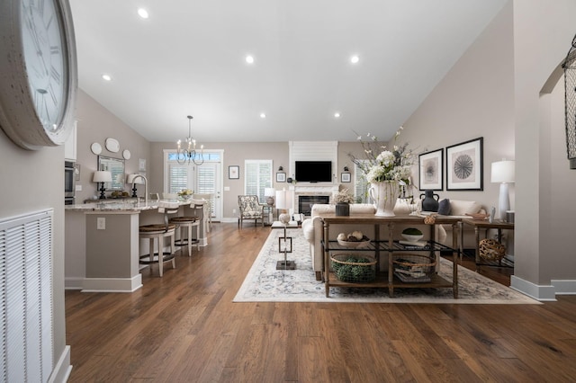 390 Buckingham Blvd, Gallatin, TN 37066 - living area with dark wood-type flooring, baseboards, a glass covered fireplace, a chandelier, and high vaulted ceiling