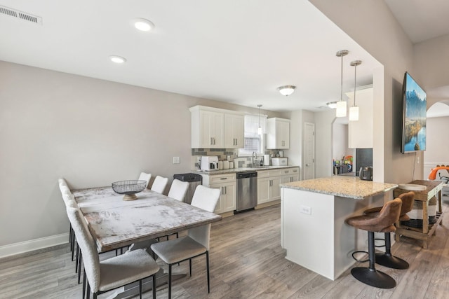 974 Bonellis Ln, Clarksville, TN 37040 - kitchen with dishwasher, a breakfast bar area, a peninsula, a sink, and light wood-style floors