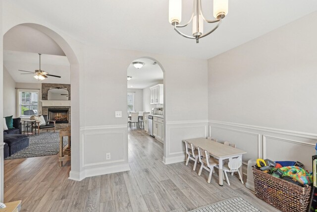 974 Bonellis Ln, Clarksville, TN 37040 - dining area featuring ceiling fan, light wood-type flooring, a wainscoted wall, a chandelier, and arched walkways