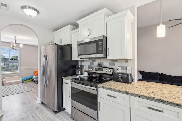 974 Bonellis Ln, Clarksville, TN 37040 - kitchen featuring appliances with stainless steel finishes, white cabinets, light stone counters, light wood-style flooring, and tasteful backsplash