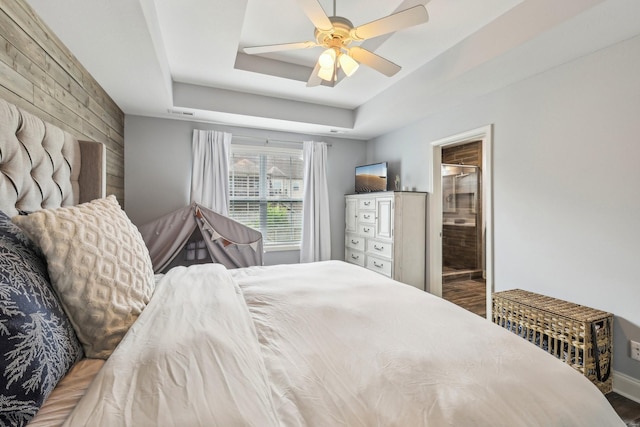 974 Bonellis Ln, Clarksville, TN 37040 - bedroom featuring wooden walls, a tray ceiling, a ceiling fan, and connected bathroom