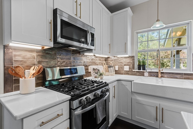 3224 Nolen Ln, Franklin, TN 37064 - kitchen featuring appliances with stainless steel finishes, a sink, decorative backsplash, white cabinets, and decorative light fixtures