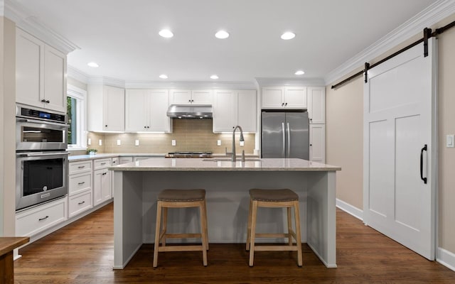 414 Gentlemens Rdg, Signal Mountain, TN 37377 - kitchen with stainless steel appliances, a barn door, a sink, under cabinet range hood, and a kitchen island with sink