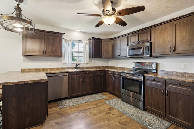 4010 Swift Springs Ct, Goodlettsville, TN 37072 - kitchen featuring appliances with stainless steel finishes, a sink, a peninsula, light wood-style flooring, and ceiling fan