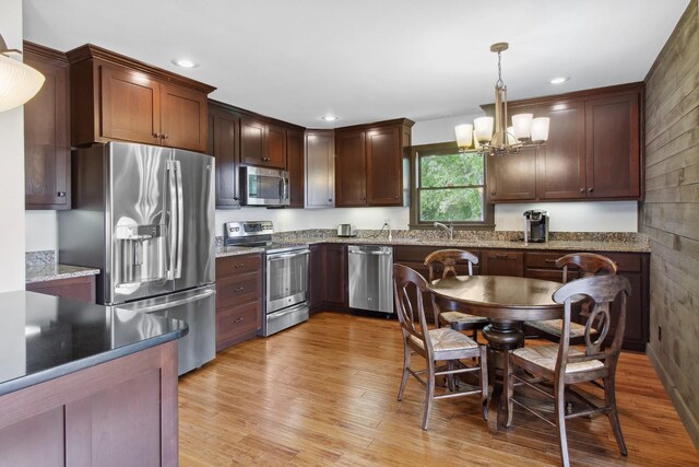 100 Acree Ln, Estill Springs, TN 37330 - kitchen featuring appliances with stainless steel finishes, a chandelier, light wood-type flooring, hanging light fixtures, and light stone countertops