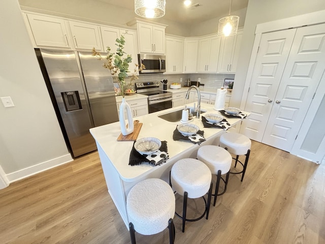 145 Lightberry Ln, Hendersonville, TN 37075 - kitchen featuring appliances with stainless steel finishes, a sink, white cabinetry, decorative backsplash, and a kitchen breakfast bar