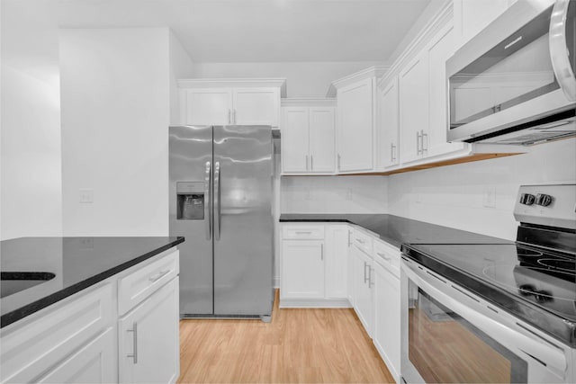 923 SE Broad St Unit A4, Murfreesboro, TN 37130 - kitchen with stainless steel appliances, white cabinets, light wood-style floors, and decorative backsplash