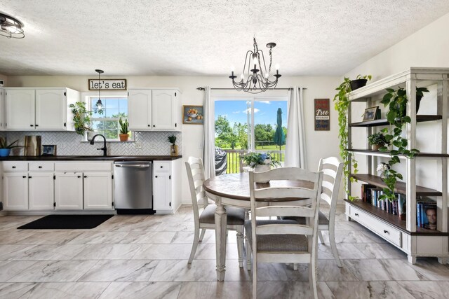 8635 Pleasant Hill Rd, Cross Plains, TN 37049 - kitchen with dishwasher, dark countertops, light marble finish floors, a chandelier, and white cabinetry